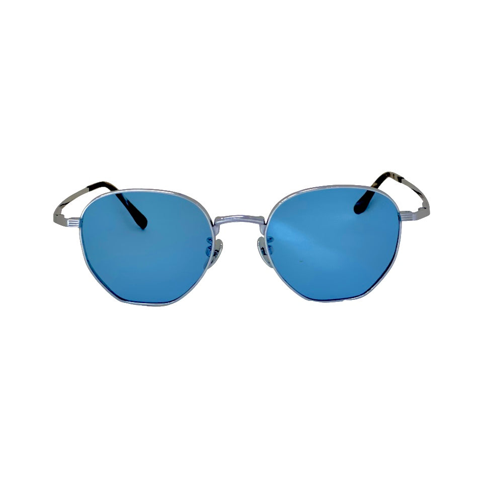 Round sunglasses with blue lenses and silver frames - ROYOON sunglasses placed on a camera lens for scale - Person wearing ROYOON while hiking a rocky trail - the titanium grain and brushed metal finish
