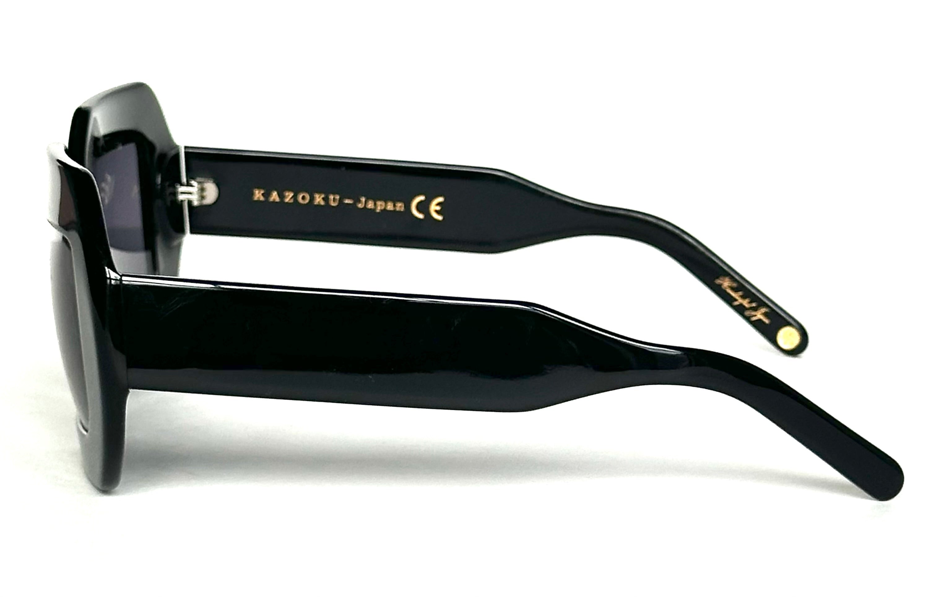 The sunglasses lying on a surface, displaying the full shape - Close-up of the lens, demonstrating its gradient tint and clarity