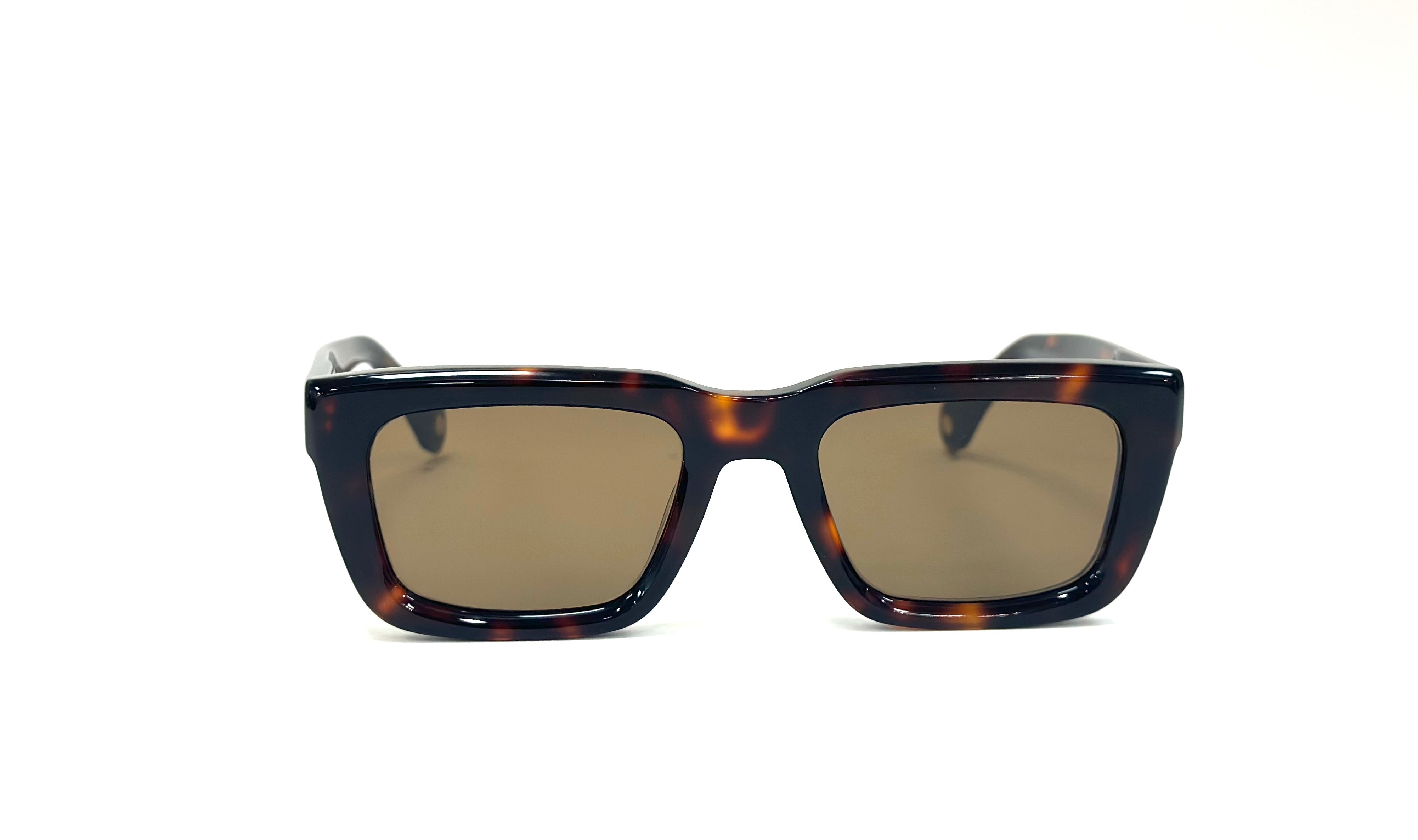 A pair of Kazoku Lunettes DIEHARD sunglasses with a square, tortoiseshell acetate frame and brown-tinted lenses - Model wearing Kazoku blue light glasses outdoors